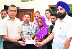 KD Bhandari, BJP MLA, gives a check for ~1 lakh to Anita, mother of the baby who had died at the Civil Hospital in Jalandhar on Wednesday. 