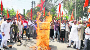 Shiv Sena activists burn a refrigerator in protest against unscheduled power cuts outside the Chief Engineers office on the Canal road in Jammu on Friday.