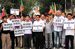 Members of the BJP Trade Cell carry placards against the Union governments move to invite foreign direct investment in Jammu on Saturday