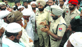 Policemen inspect the scene of the crime where he was done to death by some assailants in Nurpur village.