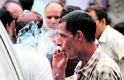 Despite a ban on smoking in public places, a man puffs on a bidi in Jammu