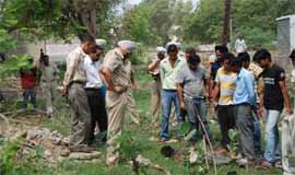 Policemen examine the spot where the body of a man was found near the railway tracks in the industrial area on Monday. The railway police and cops from Cantonment police station both arrived at the spot. 