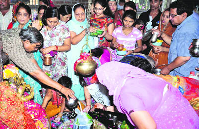 Devotees offer Ganga jal at Neeleshwar Mahadev Temple in Haridwar on Monday. 