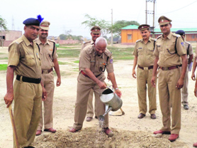 Suraj Bhan Kajal, DIG of the Sonepat group centre of the CRPF, waters a sapling on the occasion of Raising Day of the CRPF.