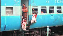 Young ragpickers put their lives on the line by climbing down a train while looking for garbage at the Jammu railway station.