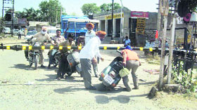 A commuter tries to cross a closed level crossing on Sherpur Road in Jagraon.