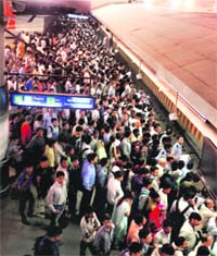 Passengers wait for a Metro train at Rajiv Chowk station in New Delhi on Monday