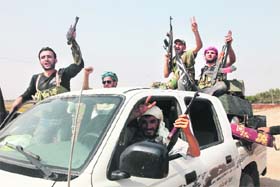 SMELLING VICTORY: Syrian rebel fighters celebrate after capturing a checkpoint in the village of Anadan, about 5 km from Aleppo, on Monday