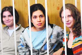 Members of the all-girl punk band Pussy Riot  (from left) Yekaterina, Nadezhda and Maria  sit behind bars during a court hearing in Moscow