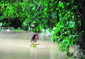 A girl wades through floodwaters following heavy rains caused by a tropical storm in Manila on Monday