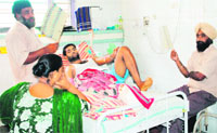 Family members use hand fans to comfort an ailing patient at the Civil Hospital in Amritsar on Tuesday. Photo: Vishal KUmar