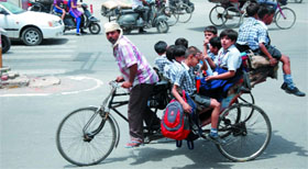 A rickshawpuller ferries ten students on his improvised rickshaw in Bathinda. Such vehicles not only flout the traffic norms but also endanger lives of the students.