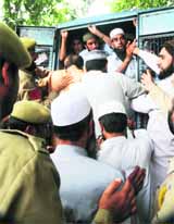 Members of the Mutahida Ulmayee Aehlay Sunnah being rounded up during the Khanyar chalo march in Srinagar on Tuesday. 