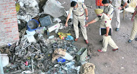 Police officials inspect the site of the blast in Muthi area.