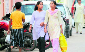 A boy and a woman carry polythene bags in Jammu.
