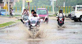 Vehicles cross the waterlogged Samadhian road in Jammu on Tuesday.