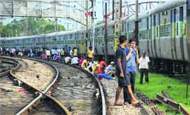 Passengers wait for resumption of train services at Naini railway station in UP.