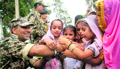 Schoolgirls tie rakhis to a Border Security Force soldier at a function organised by Global Green Peace and Environmental Protection at Suchetgarh, around 25 km from Jammu, on Wednesday. 