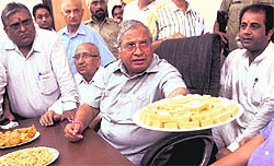 Health and Family Welfare Minister Madan Mohan Mittal offers sweets to safai sewaks who came to submit a memorandum to him in Ludhiana on Wednesday