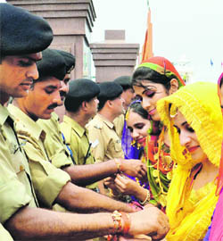 Girls tie rakhis to BSF jawans on Raksha Bandhan at the Wagah border in Amritsar on Thursday. 