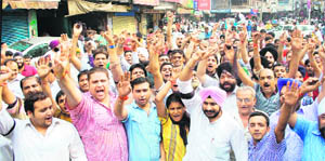 Traders hold protest at Ram Bagh Chowk in Amritsar on Thursday.