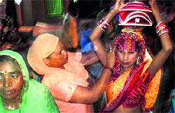 The mother of the girl child carries a pitcher while going to the well for the kuan poojan ceremony in Sirsa