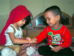 A girl ties a rakhi on the wrist of her brother on Raksha Bandhan in Dharamsala on Thursday