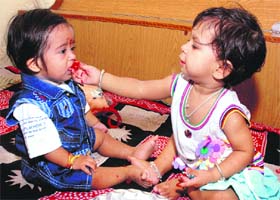 Sisterly affection A little girl offers sweets to her brother after tying rakhi on his wrist in Jalandhar on Thursday