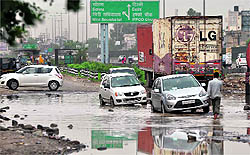 Motorists struggle to negotiate a potholed service lane on the National Highway No. 8 near Hero Honda Chowk in Gurgaon on Friday