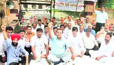 Residents sit outside the Jalandhar Cantonment Board office during a dharna. 