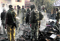 Army men conduct a search of the gutted house where Lashkar commander Abu Hanzallah was killed in Handwara in Kupwara district on Friday