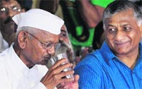 Gen VK Singh (retd) offers coconut water to Anna Hazare for breaking his fast at Jantar Mantar in New Delhi on Friday.  PTI