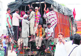 Commuters risk their lives as they hang behind a truck in Amritsar.