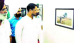 Cabinet minister Anil Joshi takes a look at paintings on the concluding day at the summer art camp