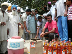 Residents of Kaoni village offering free liquor to commuters to please the Rain God in Muktsar district on Sunday. 
