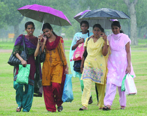 Girls enjoy evening rain in New Delhi on Sunday. 