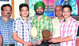 Principal Dr Jagroop Singh honours toppers Ram Kakkar and Suraj Kakkar.