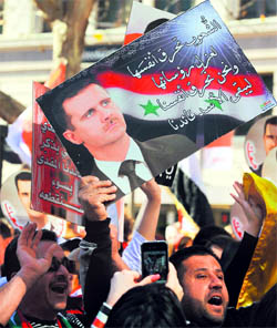 Demonstrators hold placards during a march held in support of the Syrian regime in Sydney.