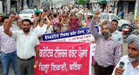 Members of the Democratic Teachers Front hold a protest march in Bathinda on Monday. The Front demanded that the salaries of teachers be paid on time.