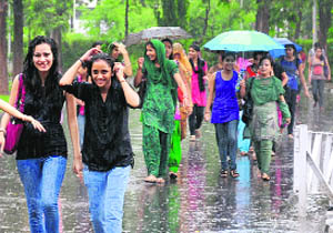 Girls protect themselves from rain outside the Postgraduate College for Girls, Sector 11. 