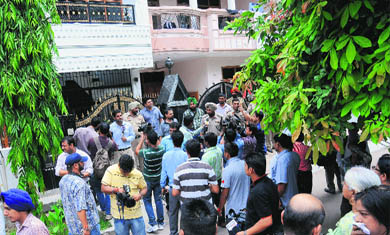 Police officials and residents of the area gather outside Fiza's house in Sector 48-C, Mohali, on Monday. 