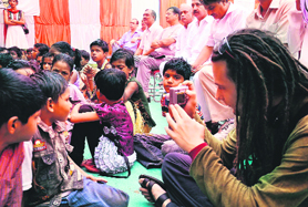 A foreign national clicks pictures of children at a community event organised at Chakarpur village in Gurgaon recently.