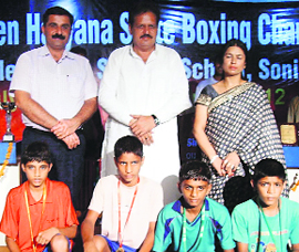 INLD general secretary Surender Dahiya (centre) and Little Angel School chairman Ashish Arya with the winners of the boxing championship at Sonepat.