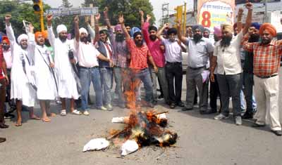 Members of the Sikh Talmel Committee protest against the attack on a gurdwara in the USA by burning an effigy of racism and hate crime at the Company Bagh chowk in Jalandhar. 