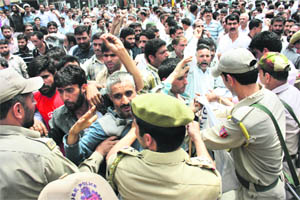 Policemen hold back Jammu and Kashmir State Road Transport Corporation workers during a protest march towards civil secretariat in Srinagar on Monday.
