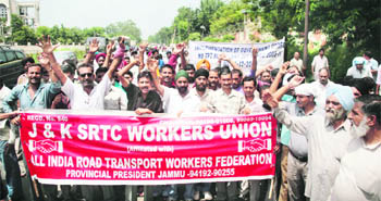 Members of  the J&K SRTC  Workers Union during a protest rally in Jammu on Monday. 