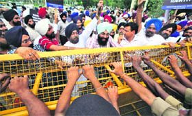 Protesters push a barricade as policemen try to stop them for marching towards the US Embassy during a protest against Wisconsin shooting incident, in New Delhi on Monday.