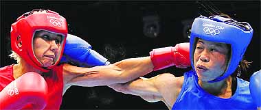 Maroua Rahali of Tunisia (in red) and MC Mary Kom trade punches during the women's flyweight boxing quarterfinals on Monday. 