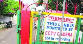A CCTV camera (circled) at the entry of a society with a warning board in Sector 7, Panchkula.