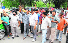 Auto-rickshaw drivers protest in front of the Chandigarh Municipal Corporation building in Sector 17, Chandigarh, on Tuesday.